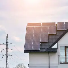 Le calepinage panneau solaire sur le toit d'une maison moderne, avec un pylône électrique en arrière-plan.