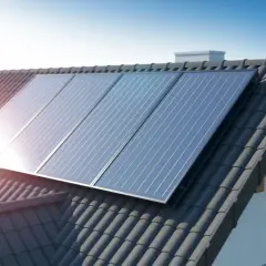 Panneaux solaires aérovoltaïques brillent sur un toit de tuiles sombres, captant l'énergie du soleil pour une maison écoresponsable.