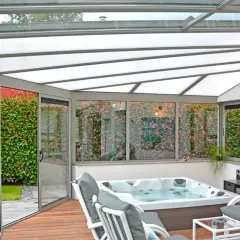 Veranda avec jacuzzi et salon, profitant d'une isolation toiture veranda par l'interieur pour un confort optimal toute l'année.