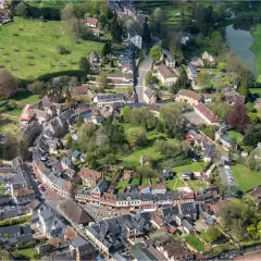 Vue aérienne d'un village pittoresque, un schéma directeur immobilier exemple, avec ses maisons aux toits de tuiles, ses rues sinueuses et son étang.