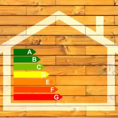 Diagramme d'efficacité énergétique maison, avec une échelle de A à G sur fond de bois.