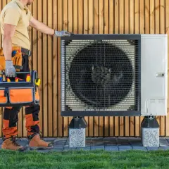 Un technicien d'une entreprise de pompe à chaleur vérifie l'unité extérieure.