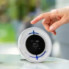 Un doigt effleure un écran affichant "387 W CONSOMMATION RÉSEAU", utile pour comment suivre sa production photovoltaïque EDF.