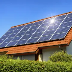 Panneaux solaires sur un toit de tuiles rouges, capturant le soleil. Un potentiel solaire toiture prometteur pour cette maison.