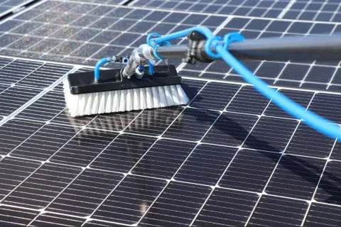 Brosse de nettoyage pour panneau solaire en action, assurant une efficacité maximale.