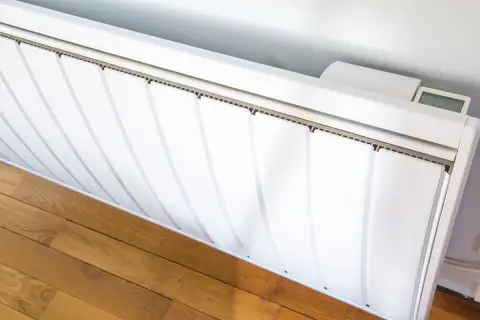 Radiateurs basse consommation blancs, modernes, avec un écran digital affichant la température. Ils sont installés sur un parquet en bois.