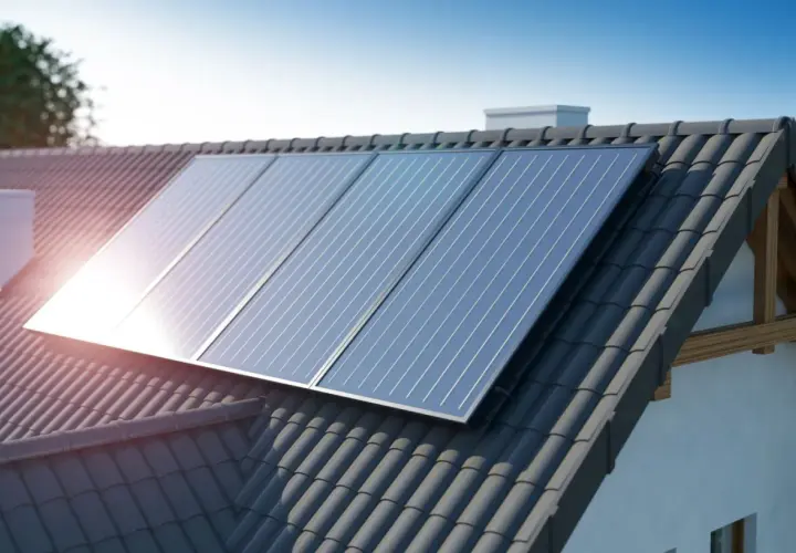 Panneaux solaires aérovoltaïques brillent sur un toit de tuiles sombres, captant l'énergie du soleil pour une maison écoresponsable.