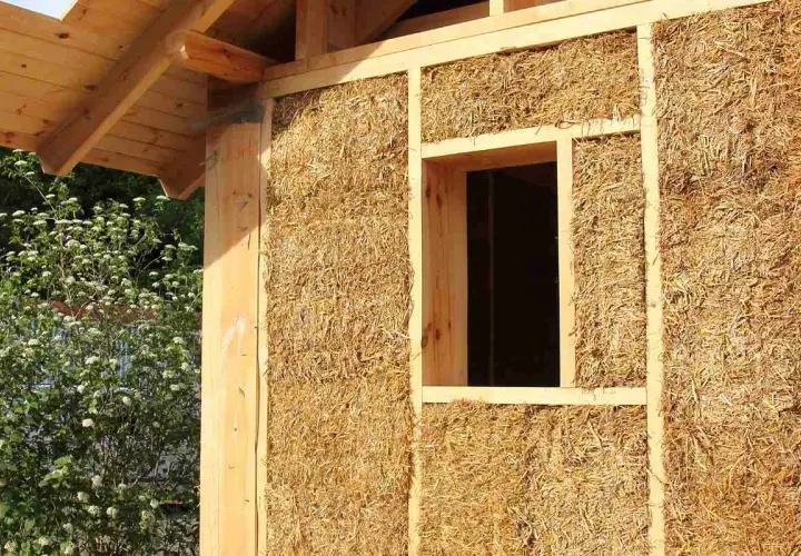 Construction d'une maison en paille, aperçu d'un mur avec fenêtre. Le prix d'une maison paille 100m2 est une question d'actualité.