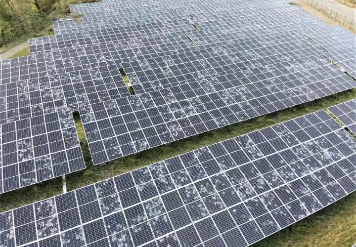 Champ de panneaux solaires recouverts de grêle, montrant la résilience de l'énergie renouvelable face aux intempéries.