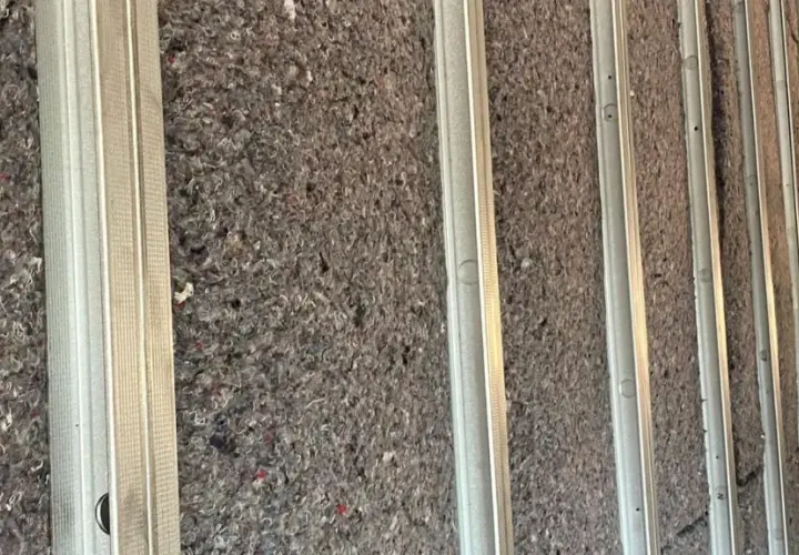 Isolation d'un mur avec de la ouate de cellulose ou de la laine de verre, prête à être recouverte.