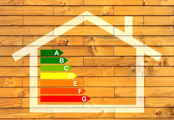 Diagramme d'efficacité énergétique maison, avec une échelle de A à G sur fond de bois.