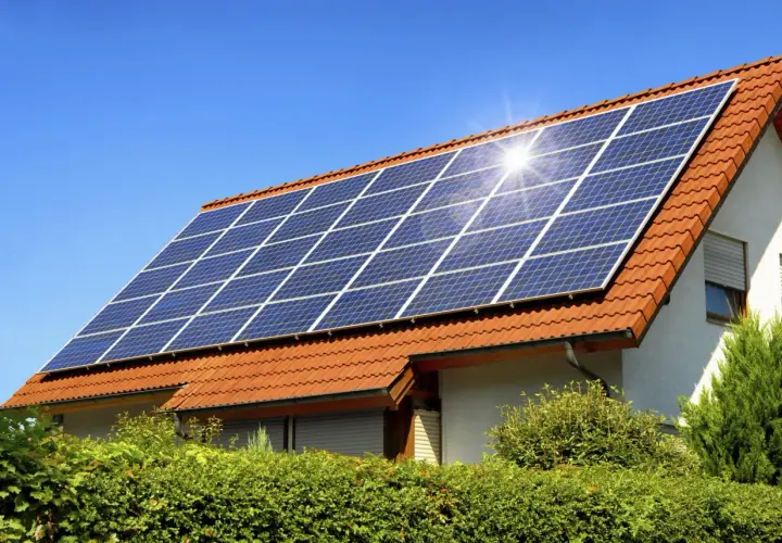 Panneaux solaires sur un toit de tuiles rouges, capturant le soleil. Un potentiel solaire toiture prometteur pour cette maison.