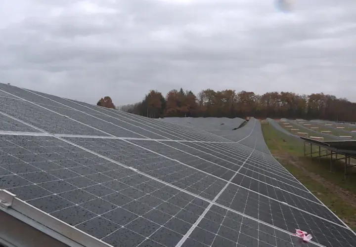 Vaste étendue de panneaux solaires sous un ciel couvert, témoignant d'un projet photovoltaïque en Nouvelle-Aquitaine.