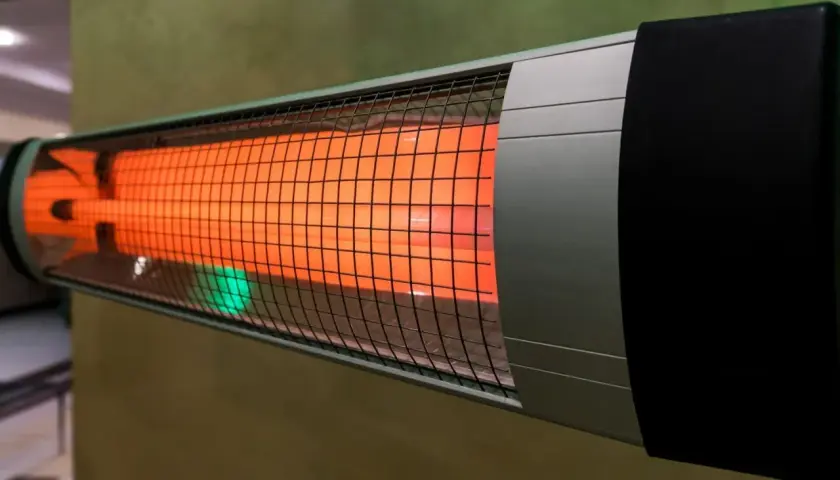 Un appareil de chauffage infrarouge diffuse une douce chaleur orangée, parfait pour réchauffer une pièce.