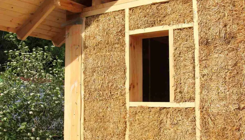 Construction d'une maison en paille, aperçu d'un mur avec fenêtre. Le prix d'une maison paille 100m2 est une question d'actualité.