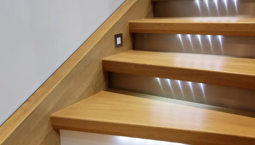 Escalier moderne en bois avec éclairage LED intégré. L'ossature bois des marches crée une ambiance chaleureuse et sécurisante.