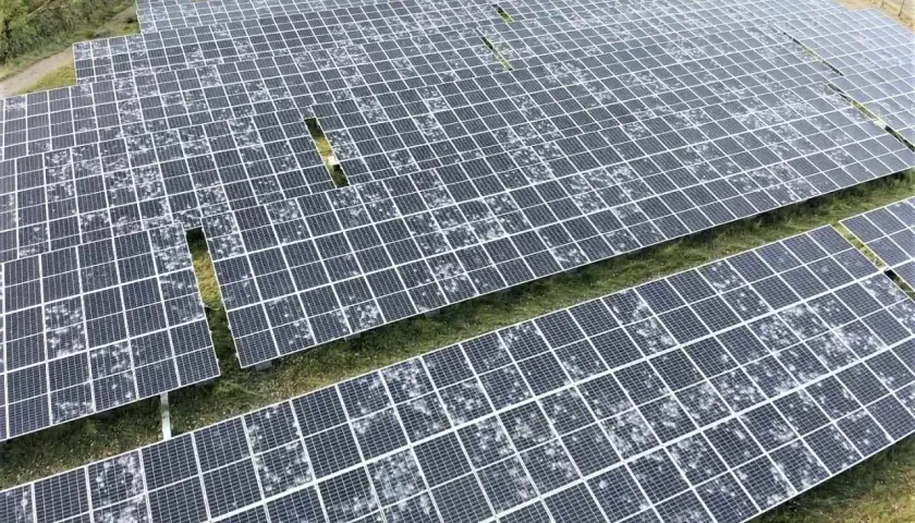 Champ de panneaux solaires recouverts de grêle, montrant la résilience de l'énergie renouvelable face aux intempéries.