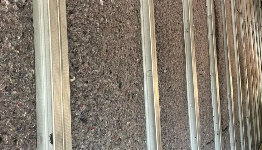 Isolation d'un mur avec de la ouate de cellulose ou de la laine de verre, prête à être recouverte.