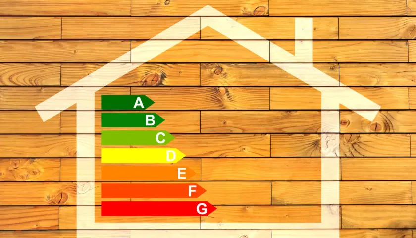 Diagramme d'efficacité énergétique maison, avec une échelle de A à G sur fond de bois.