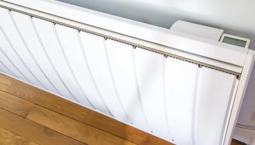 Radiateurs basse consommation blancs, modernes, avec un écran digital affichant la température. Ils sont installés sur un parquet en bois.