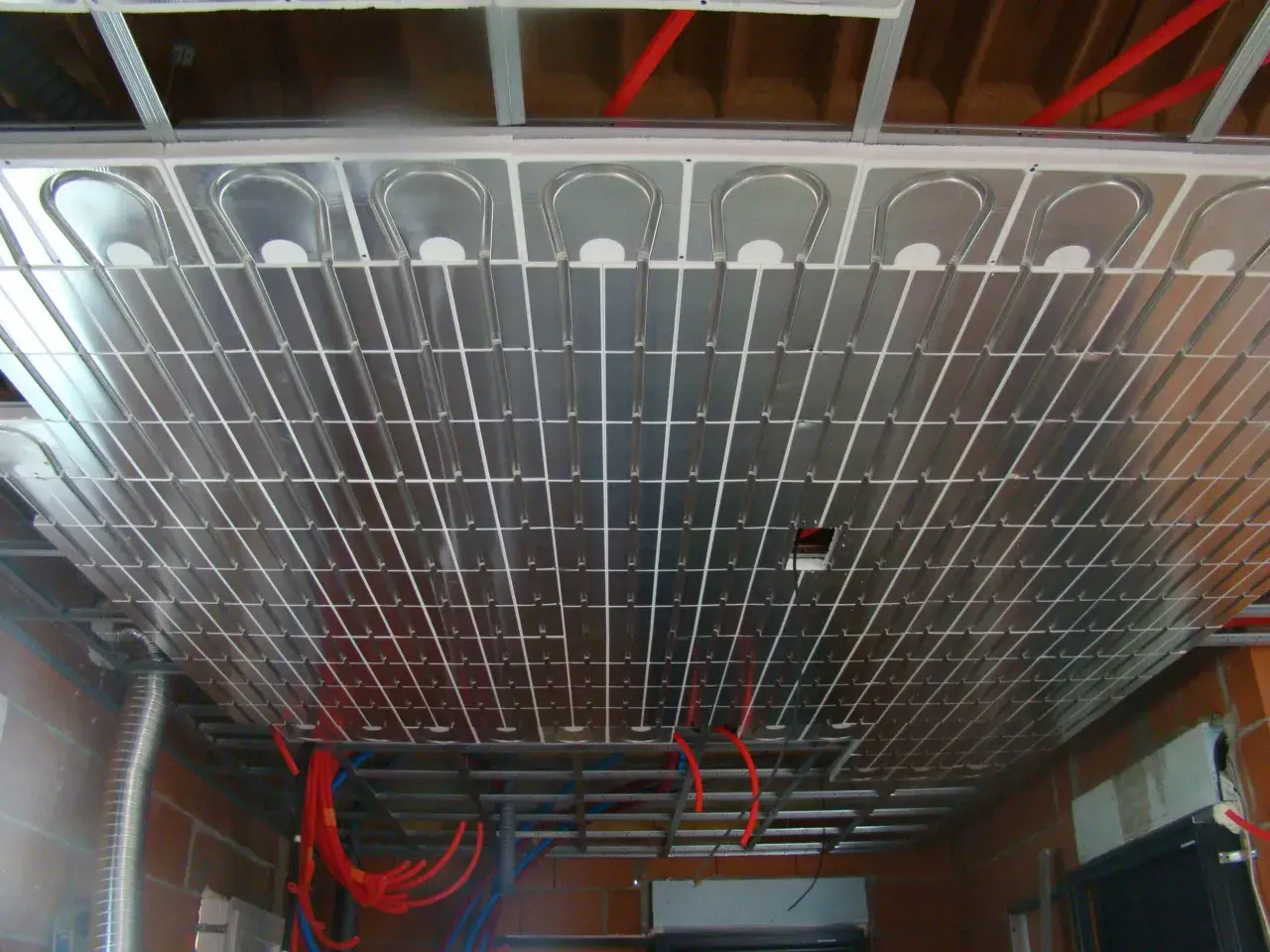 Système de chauffage par le plafond, avec des tubes en cuivre intégrés dans des panneaux réfléchissants. Ce mur chauffant promet un confort thermique optimal.