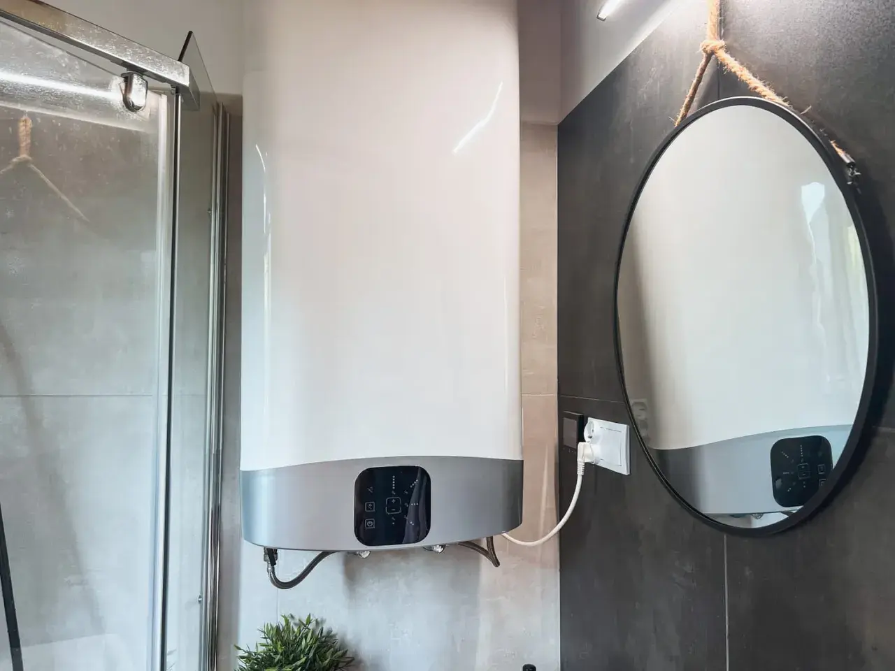 Chauffe-eau électrique instantané : les inconvénients de son installation dans une petite salle de bain. Miroir rond suspendu.