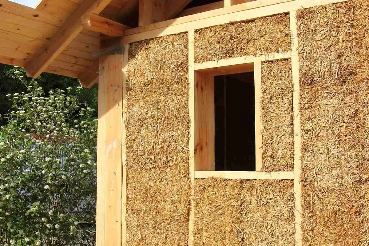 Construction d'une maison en paille, aperçu d'un mur avec fenêtre. Le prix d'une maison paille 100m2 est une question d'actualité.