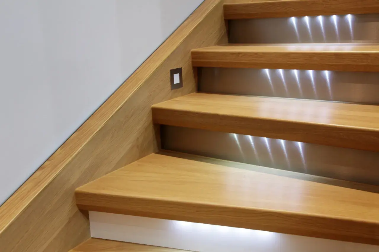 Escalier moderne en bois avec éclairage LED intégré. L'ossature bois des marches crée une ambiance chaleureuse et sécurisante.