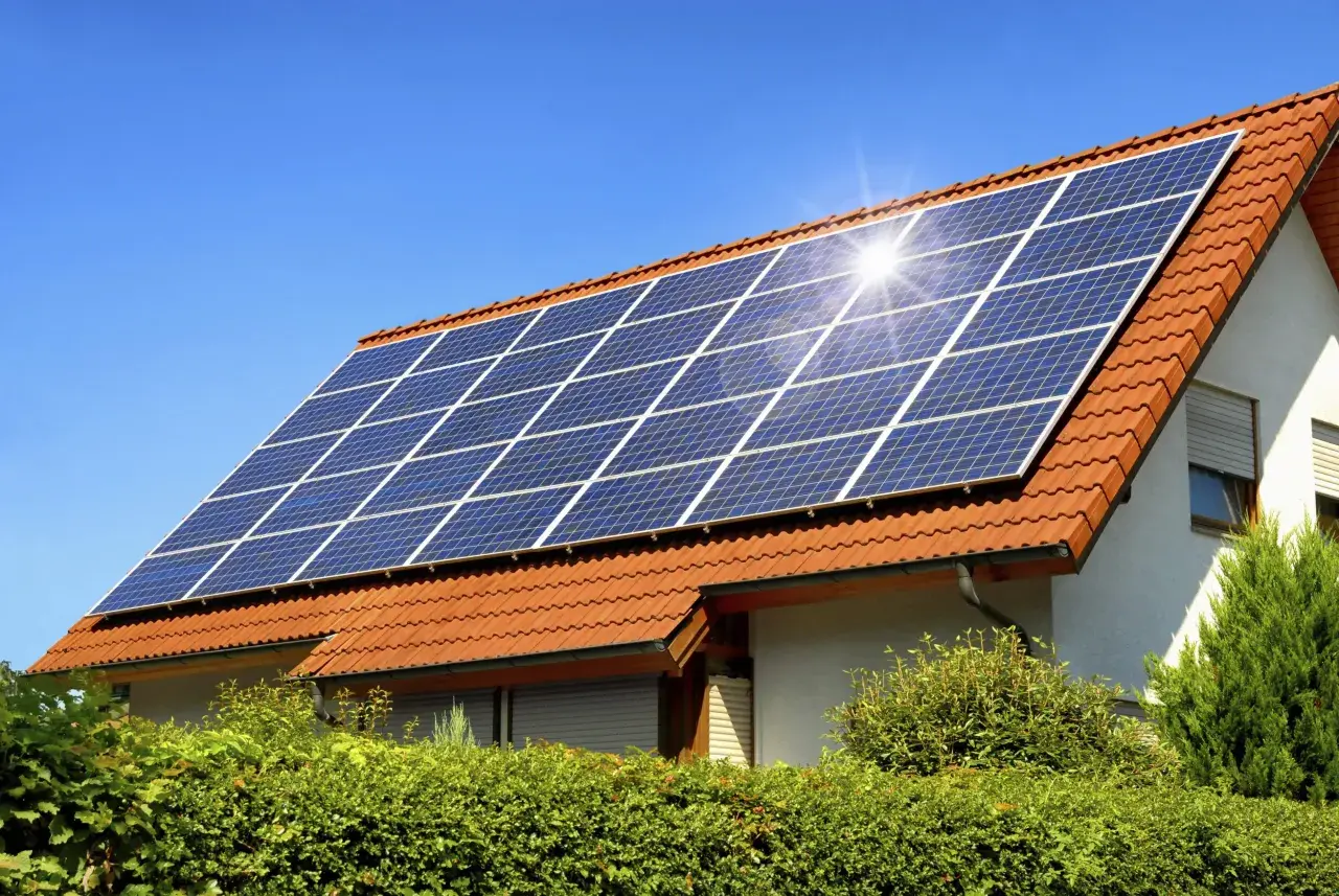 Panneaux solaires sur un toit de tuiles rouges, capturant le soleil. Un potentiel solaire toiture prometteur pour cette maison.
