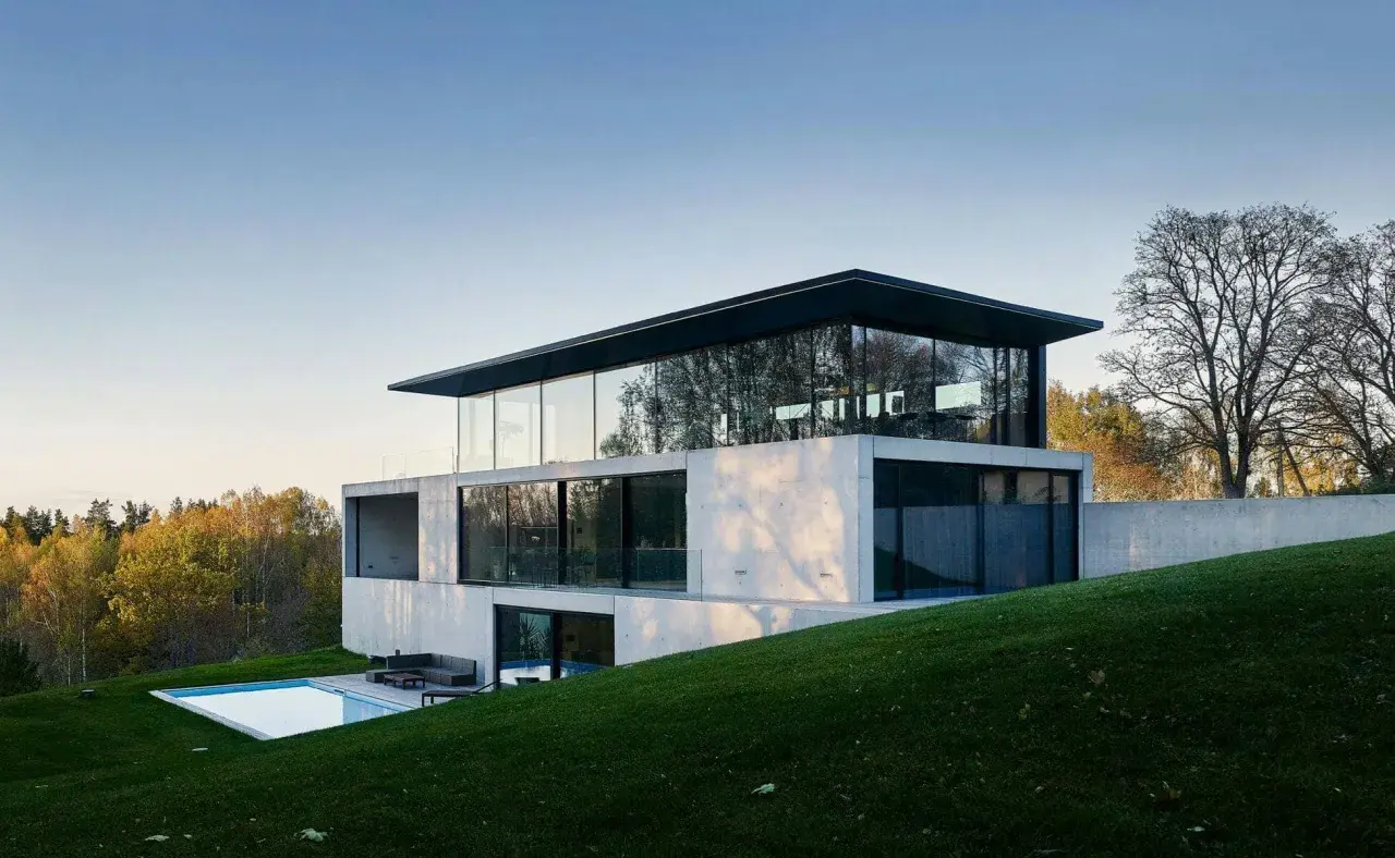 Une maison positive aux lignes épurées, avec une piscine et une vue sur la forêt.