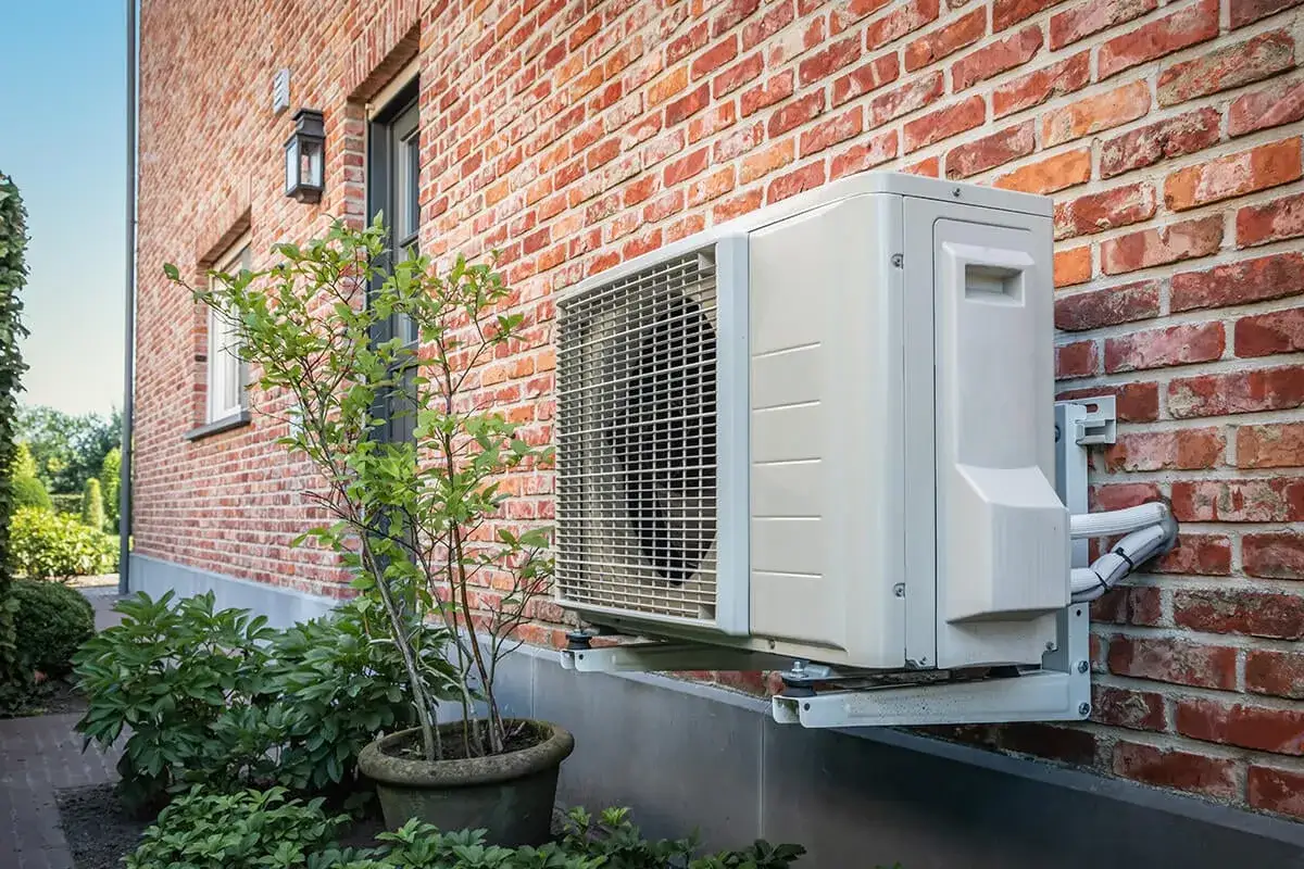 Unité extérieure d'une pompe à chaleur air air, installée sur un mur de briques. Avis positifs sur ce système de chauffage et climatisation.