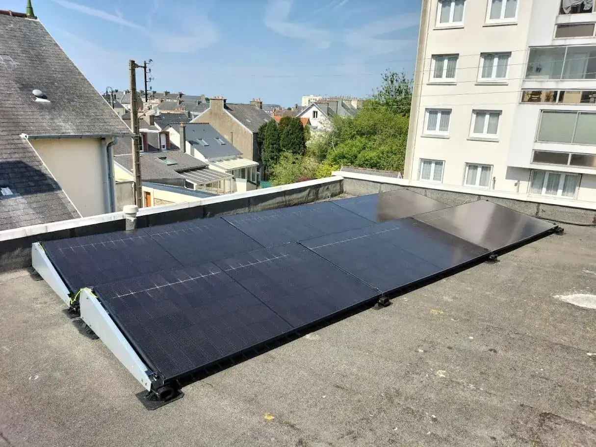 Panneaux solaires install&eacute;s sur un toit plat, offrant une solution d'&eacute;nergie renouvelable. Une bonne assurance panneau solaire est essentielle pour prot&eacute;ger cet investissement.